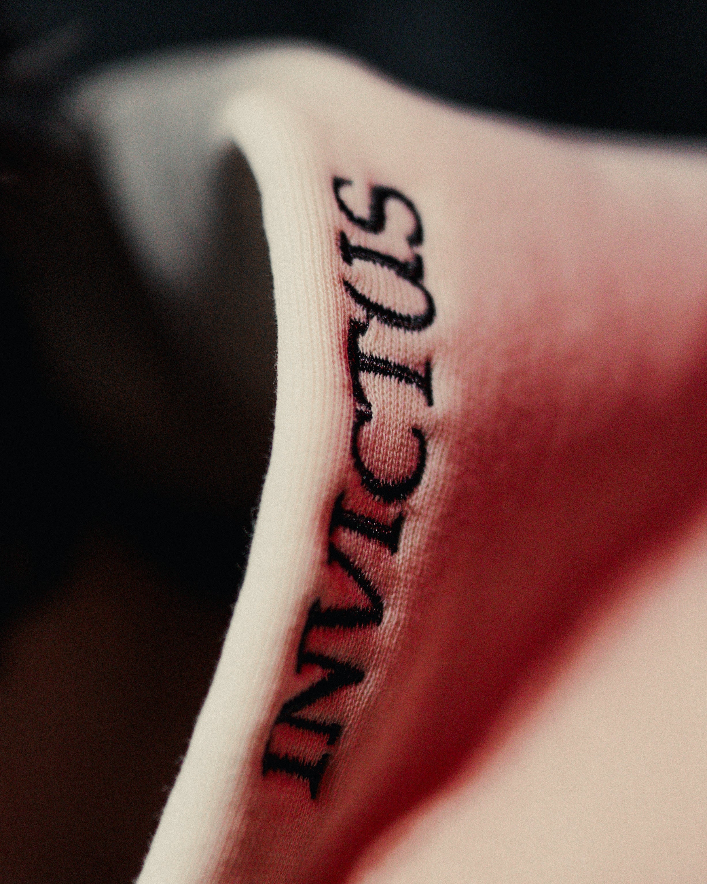 Embroider of the word 'INVICTUS' on an off-white hood